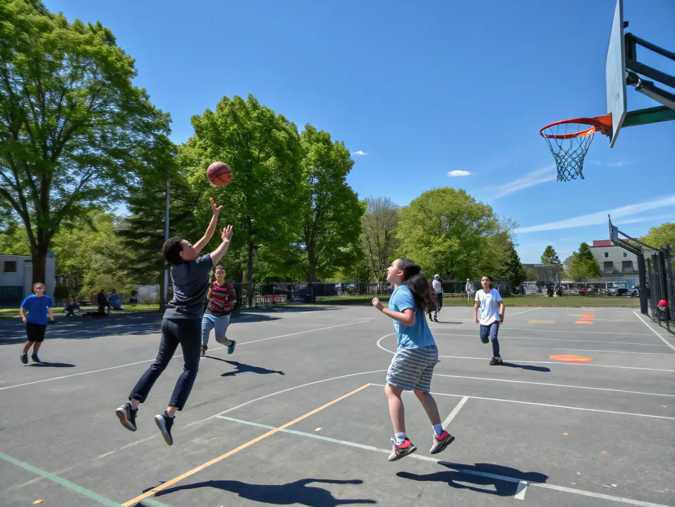 A group of students participating in a basketball game during an ASSEPS after-school program, showcasing teamwork and physical activity.